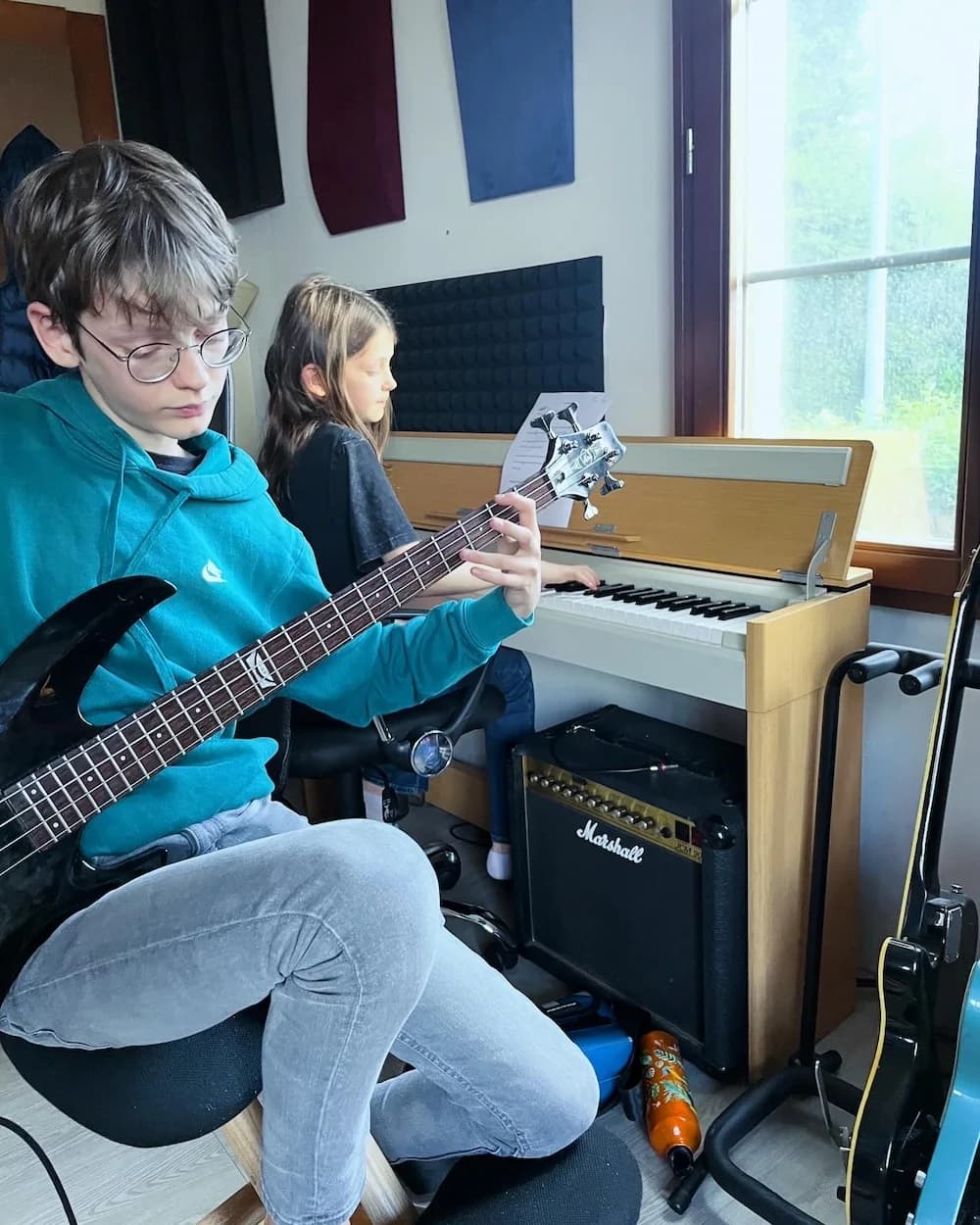 Élève jouant de la basse près du piano