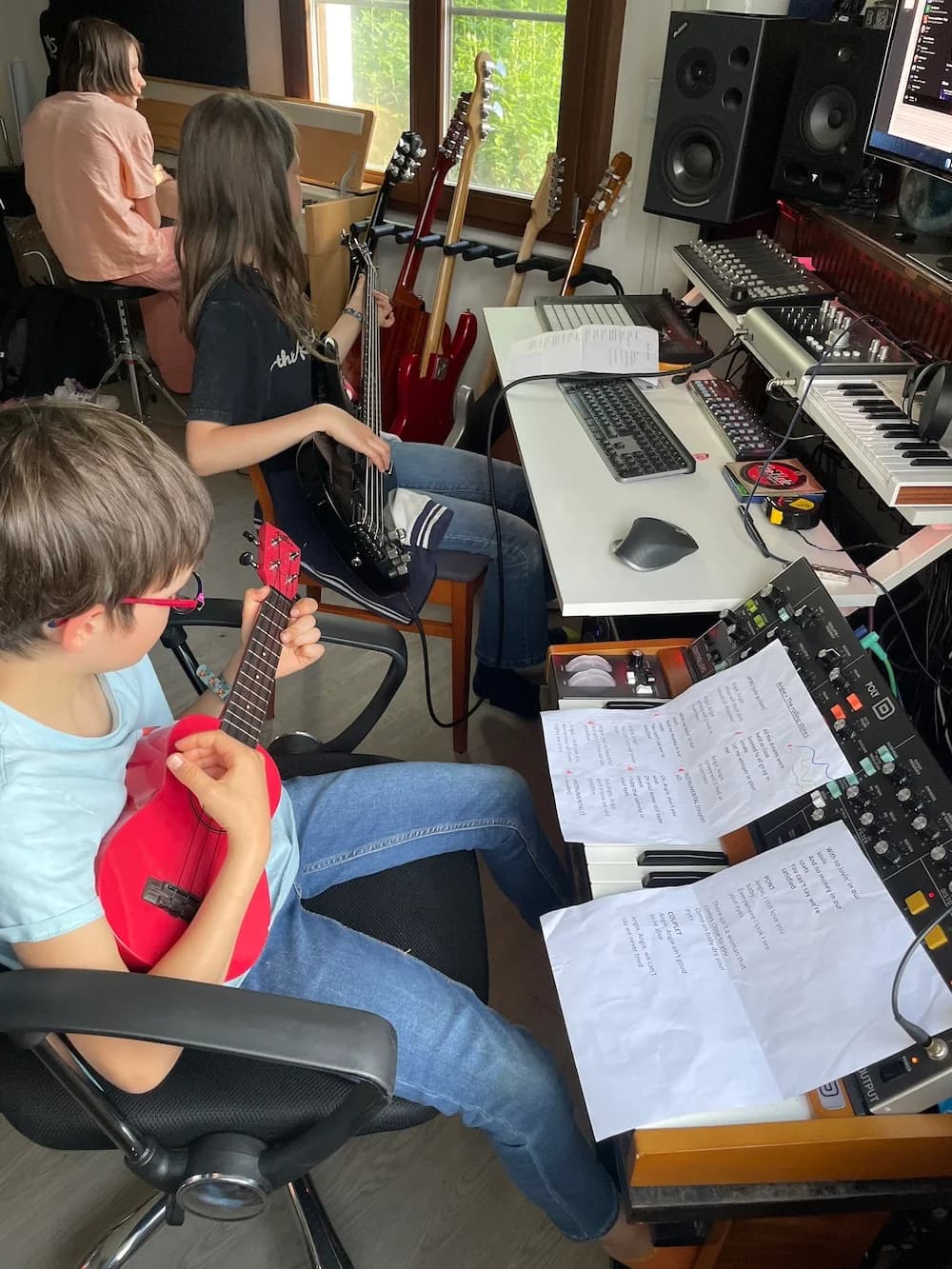 Enfants et professeur devant les claviers du studio