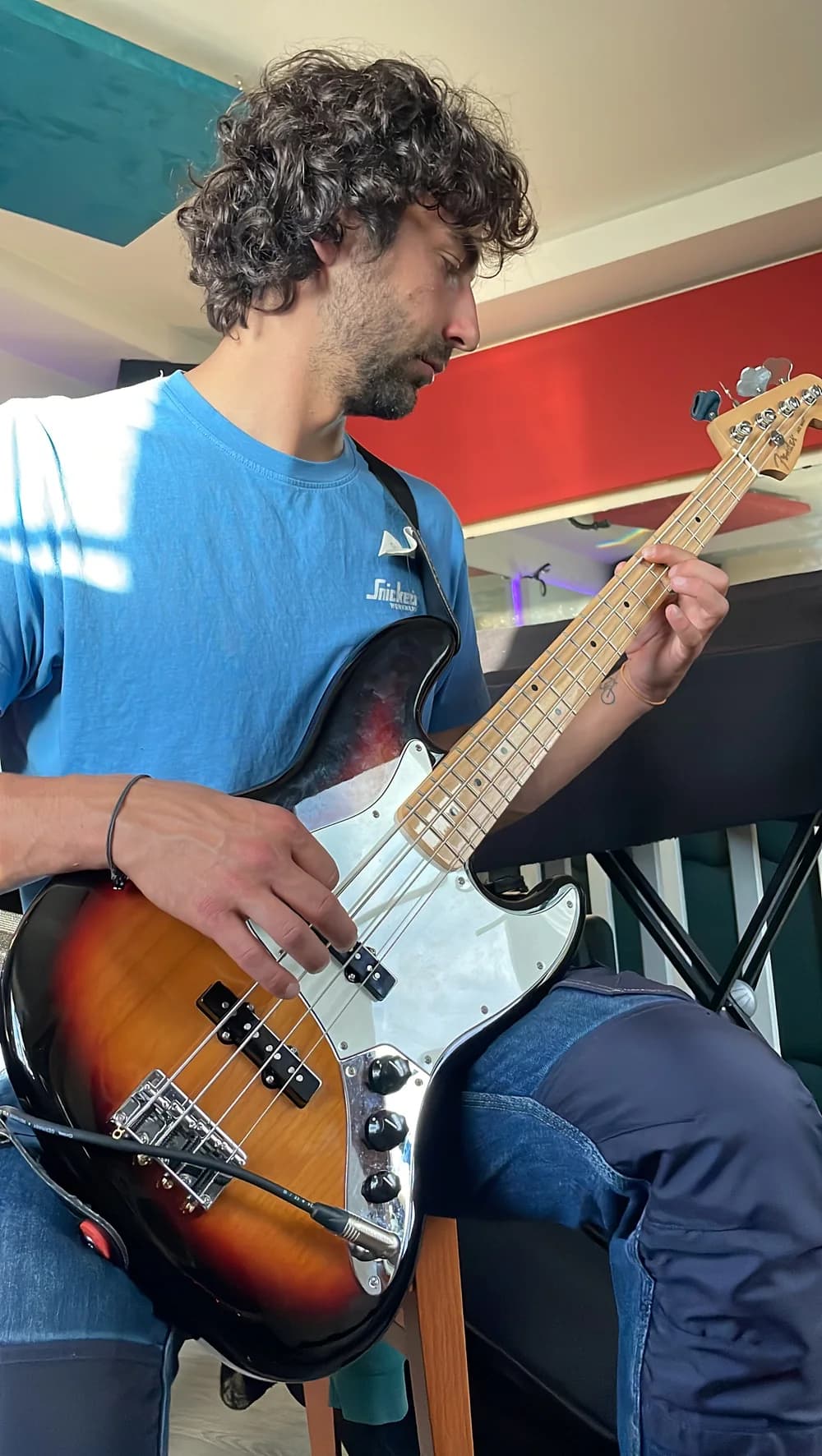 Élève jouant de la basse électrique au studio