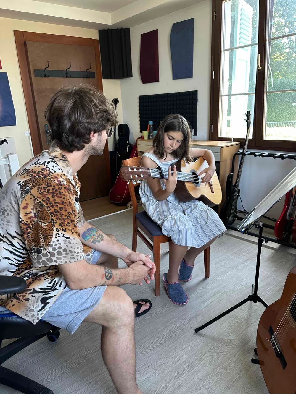 Élève et professeur travaillant la guitare ensemble